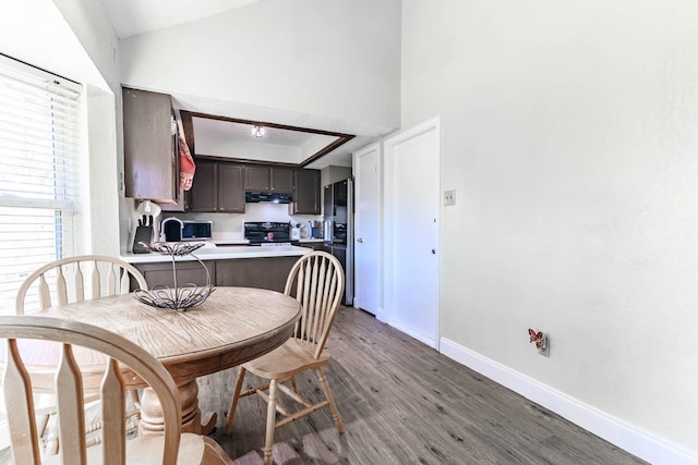 dining area with a raised ceiling and light hardwood / wood-style flooring