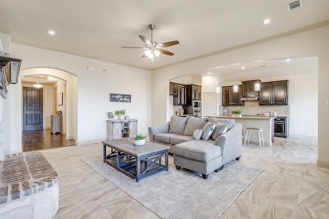 living room featuring crown molding and ceiling fan