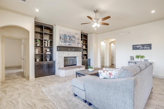 living room with crown molding, ceiling fan, and built in shelves