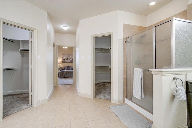 bathroom with an enclosed shower and tile patterned floors