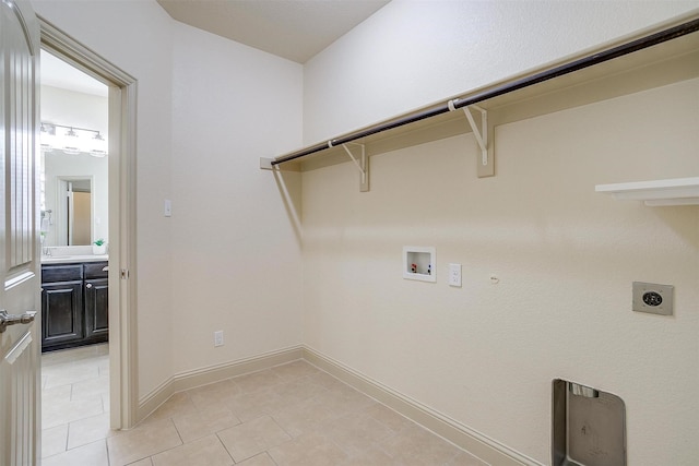 clothes washing area featuring gas dryer hookup, light tile patterned floors, hookup for a washing machine, and electric dryer hookup