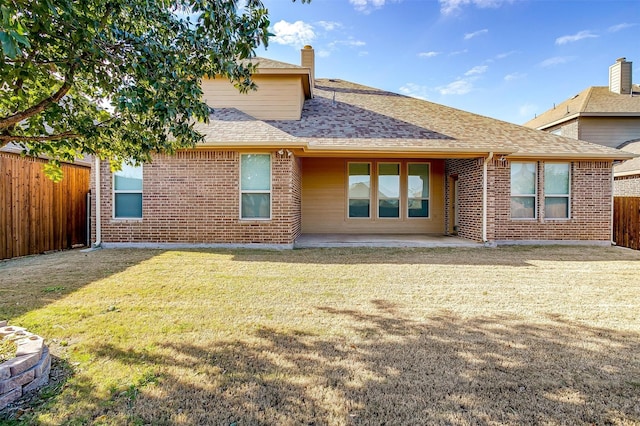 rear view of property featuring a lawn and a patio