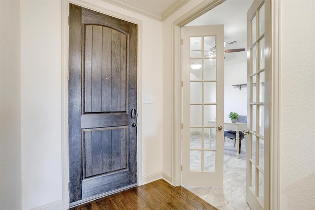 foyer entrance featuring hardwood / wood-style floors, crown molding, and french doors