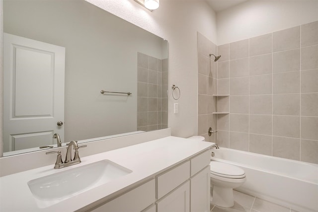 full bathroom featuring toilet, tiled shower / bath, tile patterned floors, and vanity