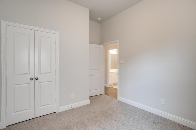 unfurnished bedroom featuring light carpet and a closet