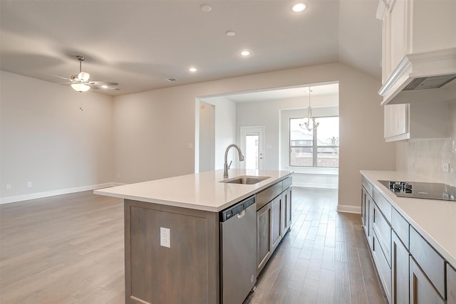 kitchen featuring decorative light fixtures, dishwasher, a center island with sink, sink, and black electric cooktop