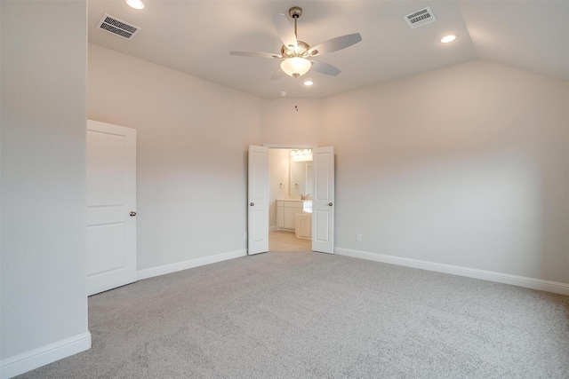 unfurnished bedroom featuring ceiling fan, light colored carpet, ensuite bathroom, and lofted ceiling