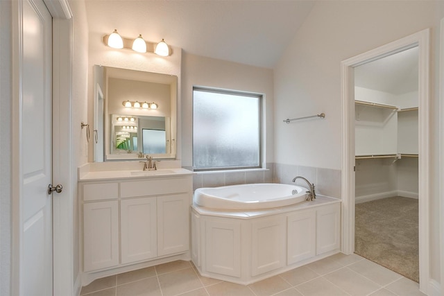 bathroom featuring tile patterned floors, vanity, a bathing tub, and lofted ceiling