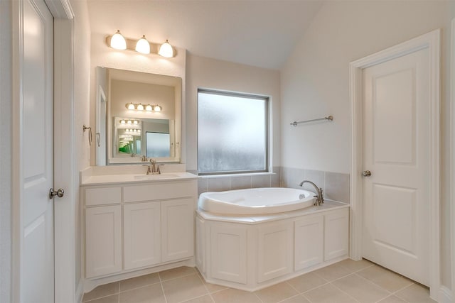 bathroom featuring vanity, a tub, vaulted ceiling, and tile patterned floors