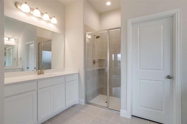 bathroom featuring tile patterned flooring, a shower with shower door, and vanity