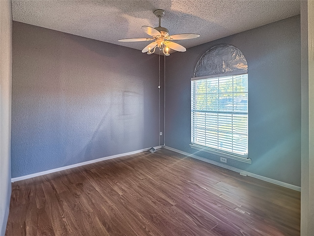 unfurnished room with dark wood-type flooring, a textured ceiling, and ceiling fan