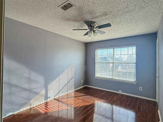 spare room featuring a textured ceiling, dark hardwood / wood-style floors, and ceiling fan