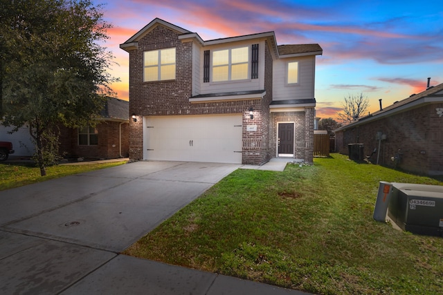 view of front of home with a yard, central AC unit, and a garage