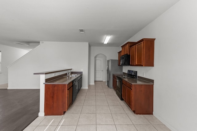 kitchen with light tile patterned floors, sink, and black appliances