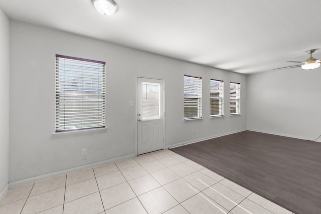 tiled empty room featuring ceiling fan