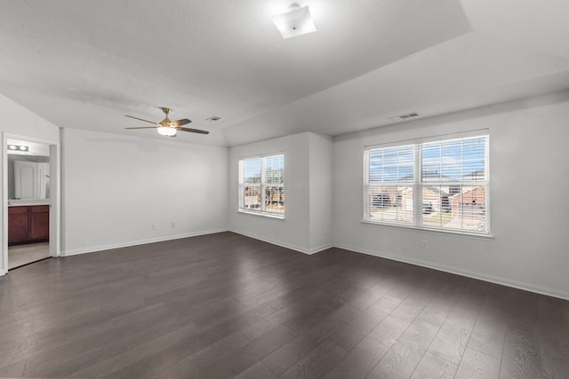 empty room with ceiling fan, lofted ceiling, and dark wood-type flooring