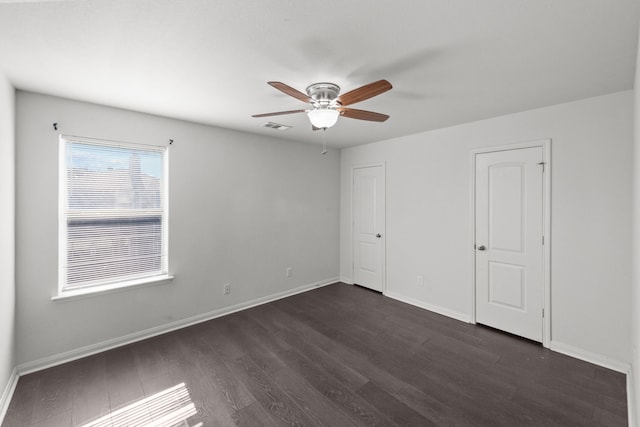 unfurnished bedroom featuring ceiling fan and dark hardwood / wood-style flooring