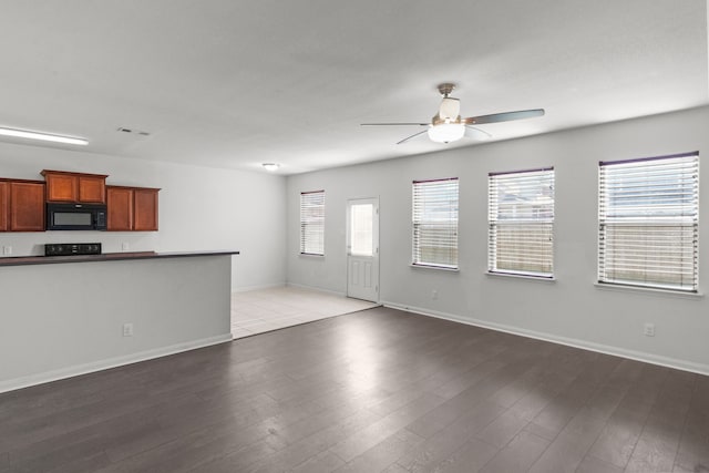 unfurnished living room featuring hardwood / wood-style flooring and ceiling fan