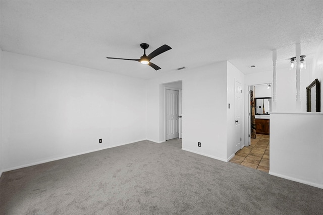 empty room with light carpet, a textured ceiling, and ceiling fan