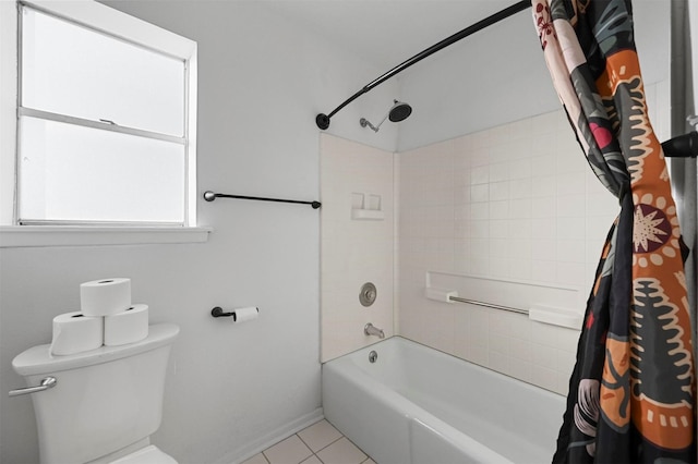 bathroom featuring tiled shower / bath combo, tile patterned flooring, and toilet