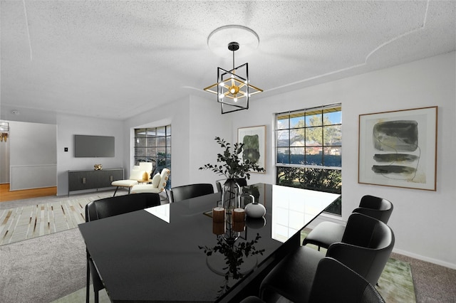 dining space featuring an inviting chandelier, light colored carpet, and a textured ceiling