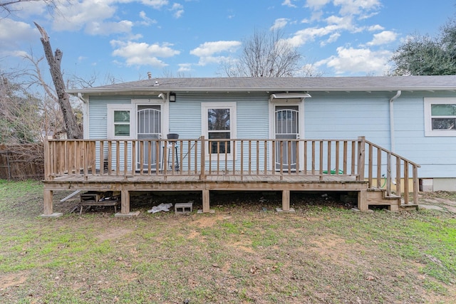 rear view of house with a deck and a lawn