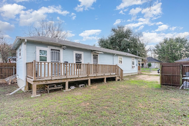 rear view of house with a lawn and a deck