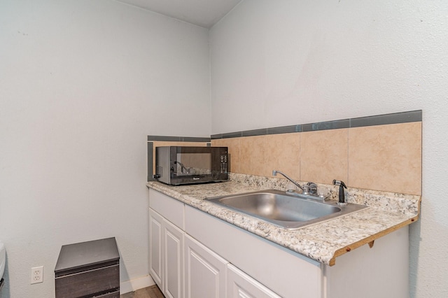 kitchen featuring sink and white cabinets