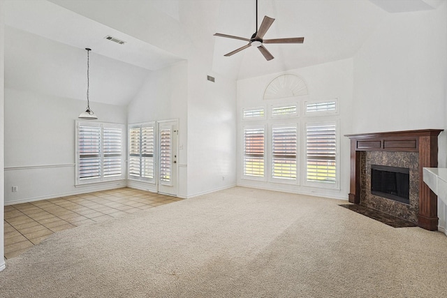 unfurnished living room featuring ceiling fan, a fireplace, light colored carpet, and plenty of natural light