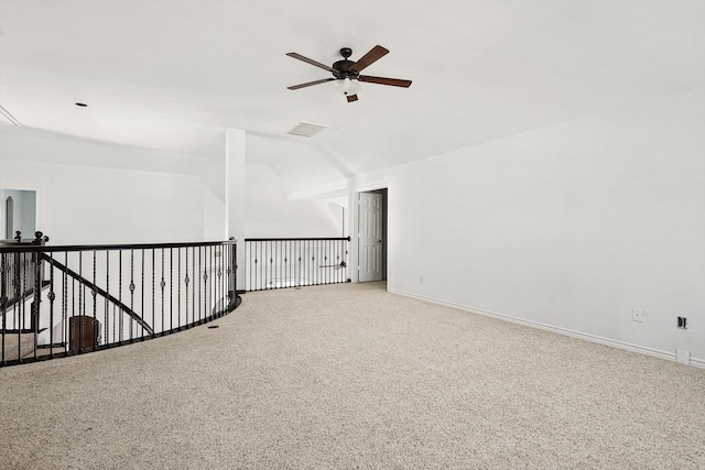 empty room with carpet flooring, vaulted ceiling, and ceiling fan