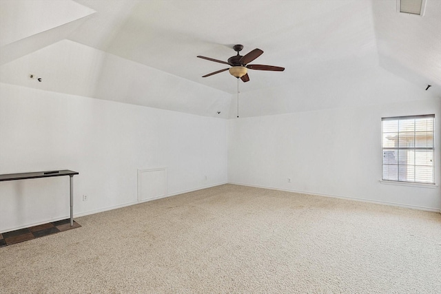 carpeted empty room with a tray ceiling, ceiling fan, and vaulted ceiling