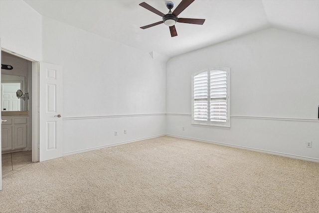 carpeted spare room with ceiling fan and lofted ceiling