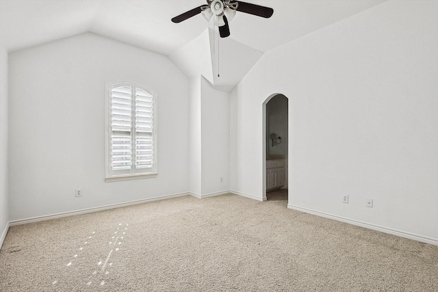 spare room featuring ceiling fan, light carpet, and vaulted ceiling