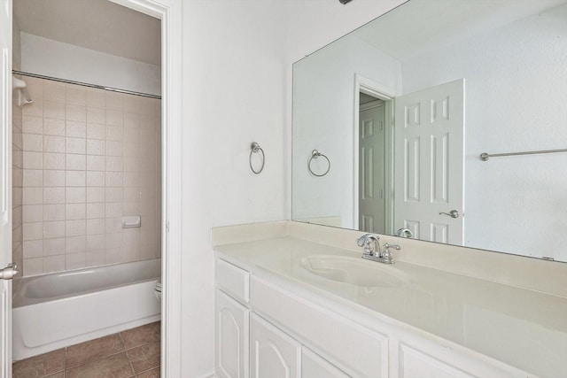 bathroom featuring tile patterned flooring, vanity, and tiled shower / bath