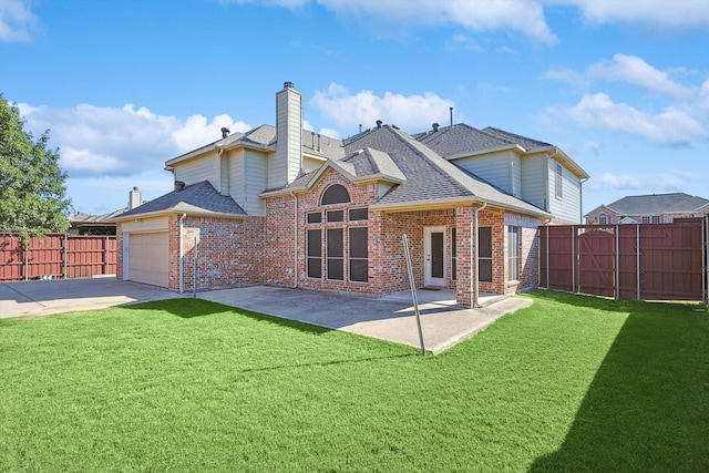 back of property featuring a yard, a garage, and a patio area