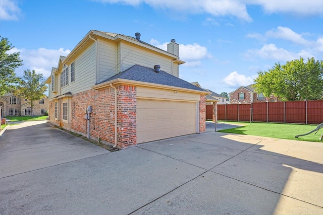 view of side of property featuring a lawn and a garage