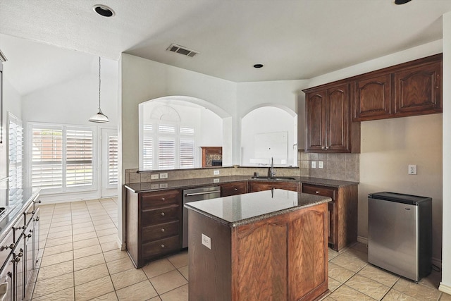 kitchen featuring kitchen peninsula, sink, light tile patterned flooring, and decorative light fixtures