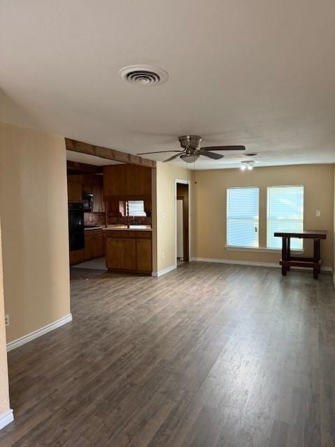 unfurnished living room with dark hardwood / wood-style flooring and ceiling fan