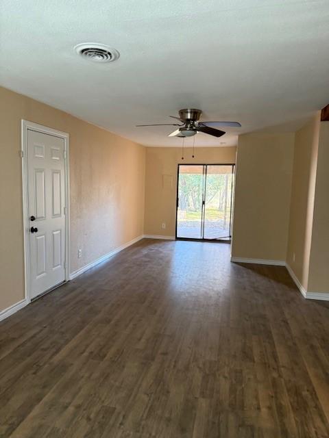 empty room with ceiling fan and dark wood-type flooring