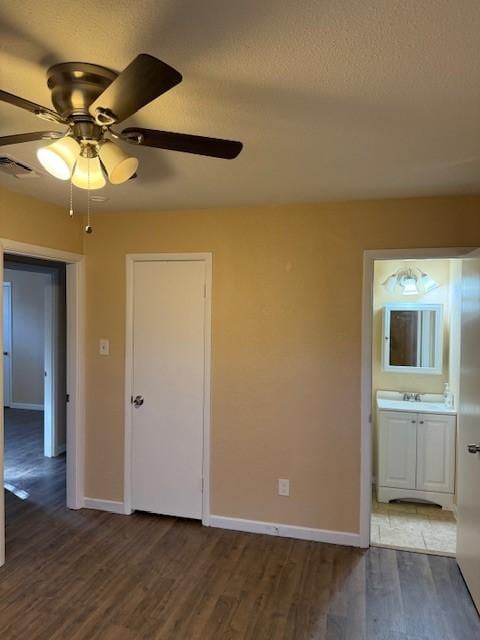 unfurnished room featuring a textured ceiling, ceiling fan, dark hardwood / wood-style flooring, and sink