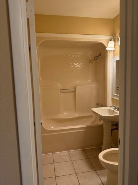 bathroom featuring tile patterned flooring, toilet, and bathing tub / shower combination