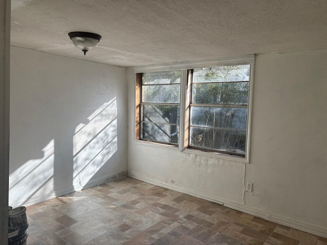 unfurnished room featuring a textured ceiling