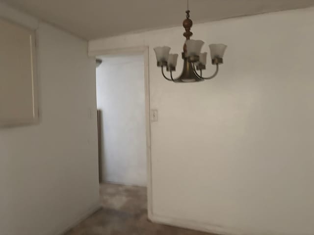 unfurnished dining area featuring an inviting chandelier