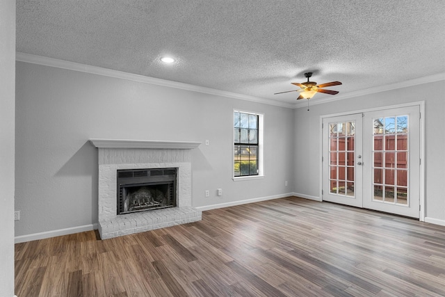 unfurnished living room featuring a fireplace, crown molding, french doors, and ceiling fan