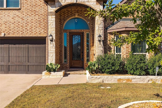 view of exterior entry featuring a yard and a garage