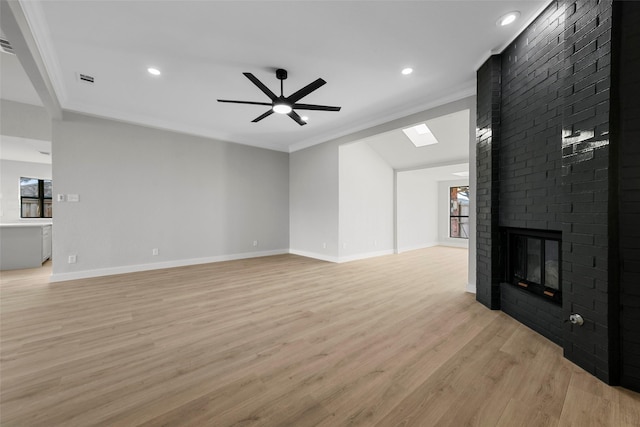 unfurnished living room featuring a fireplace, light wood-type flooring, ceiling fan, and ornamental molding