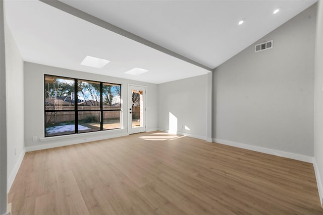 unfurnished room featuring light hardwood / wood-style flooring and vaulted ceiling with skylight