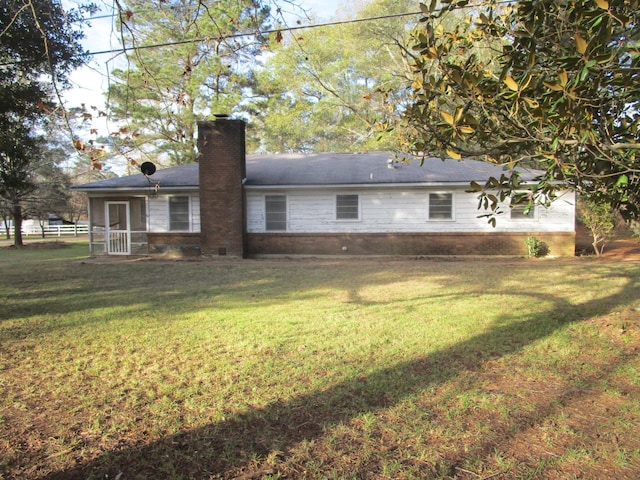 rear view of house featuring a yard