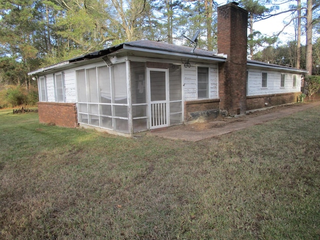 view of property exterior featuring a yard and a sunroom