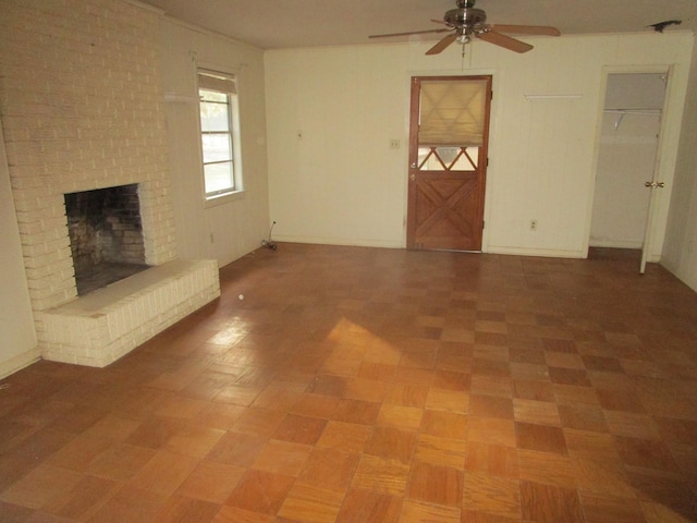 unfurnished living room with ceiling fan and a brick fireplace